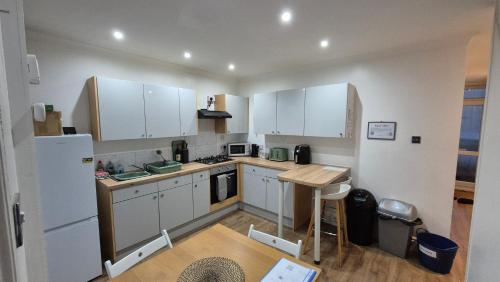 a kitchen with white cabinets and a white refrigerator at Mayfield , 2 bed slp 6 Roomy dog friendly Gosport town house in Gosport