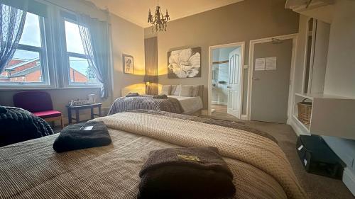 a bedroom with two beds and a chandelier at St Andrews house Hotel in Preston