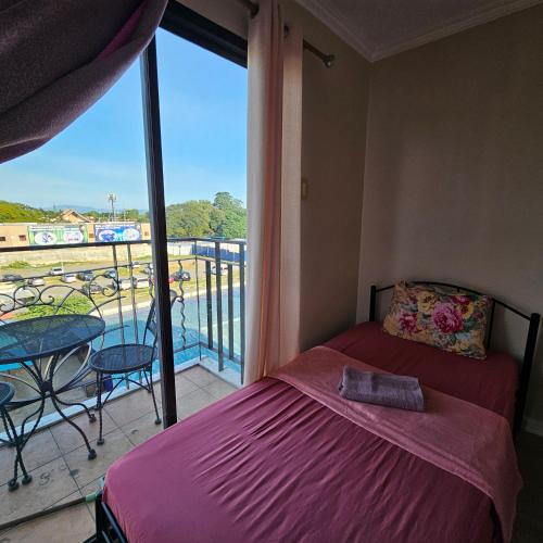 a bedroom with a bed and a balcony with a view at One oasis condo 1bedroom Ltype in Davao City
