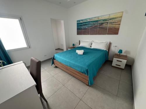 a bedroom with a bed with a blue bedspread at Lux Maris in Mazara del Vallo