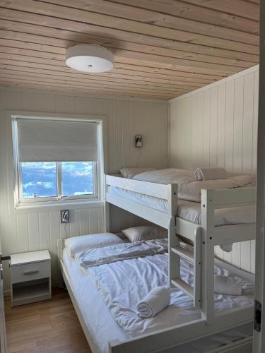 two bunk beds in a room with a window at Sauna & Mountain Views - Ski-in Ski-out Luxury in Vossevangen