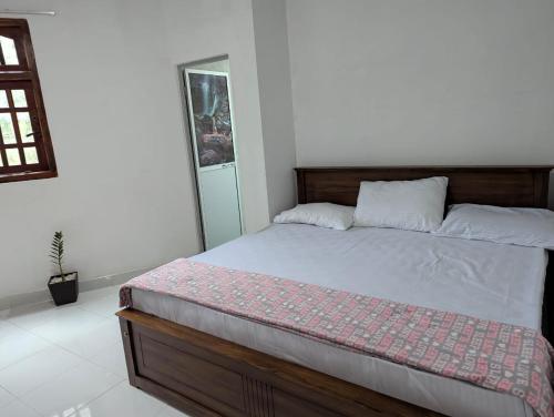 a bedroom with a bed in a white room at Wellassa Hillside Villa in Kendagolla