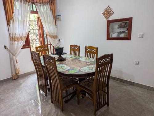 a dining room table with four chairs and a table and chairsktop at Wellassa Hillside Villa in Kendagolla