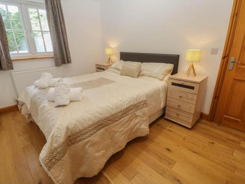 a bedroom with a large bed with towels on it at The Coach House in Hayle