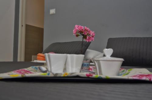 a table with a tray with a flower on it at Il Vicolo B&B in Milazzo
