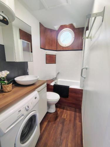 a bathroom with a toilet and a sink and a washing machine at escapade à Wimereux in Wimereux