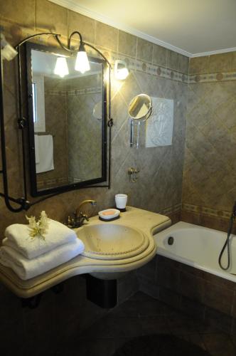 a bathroom with a sink and a tub and a mirror at Bella Villa in Vaia