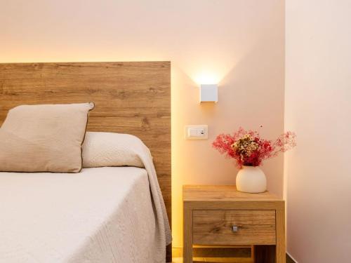 a bedroom with a bed and a vase with flowers on a table at Hotel Punta San Francesco in Vieste