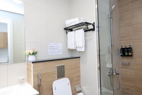 a bathroom with a shower and a toilet and a sink at Modern Waterfront Studio | Steps from Cleveland Clinic in Abu Dhabi
