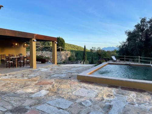 a swimming pool in a patio with a table and chairs at Casatona in San Mateo de Bages