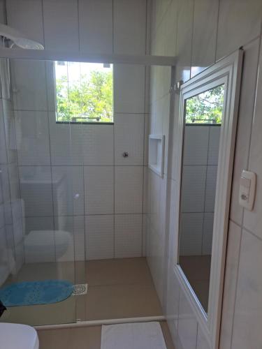 a bathroom with a shower and a glass door at Sobradinho Morro dos Ventos in Palhoça