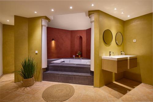 a bathroom with two sinks and a bath tub at Hotel Duinrand Drunen in Drunen
