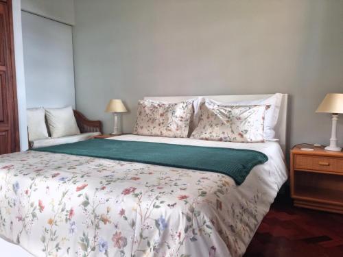 a bedroom with a large bed with flowers on it at Studio em Machico in Machico