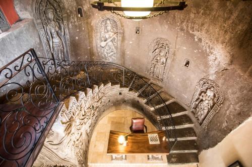 a spiral staircase in a building with paintings on the walls at Avalon Ubud Castle & SPA in Ubud