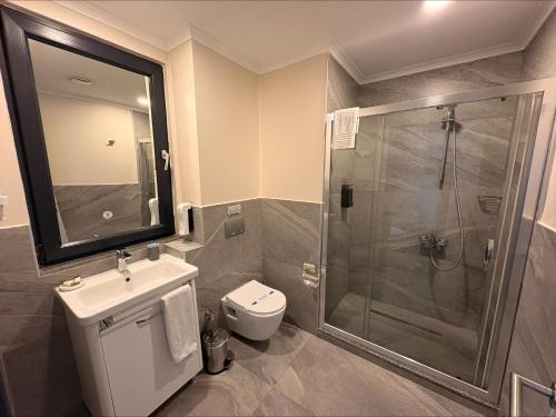a bathroom with a shower and a toilet and a sink at VALENT OTEL BUSINESS in Mehmetalanı