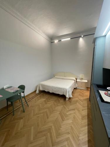 a bedroom with a bed and a table and a television at Casa Ferrara in Novara