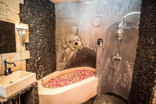 a bathroom with a bath tub filled with sprinkles at Avalon Ubud Castle & SPA in Ubud
