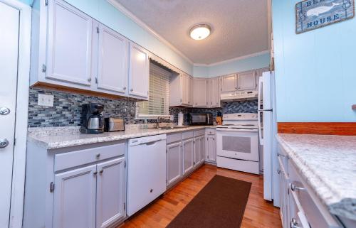 a kitchen with white cabinets and white appliances at Landing Pad - Kill Devil Hills, Oceanside, 350 Yards to Beach, Flex Stays, 4 BR in Kill Devil Hills