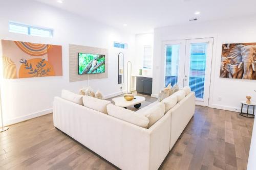 a living room with a white couch and a tv at Elite Galleria Luxe World Cup in Houston