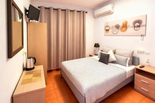 a bedroom with a bed and a television in it at ALOJAMENTO ELVAS LUSO ESPANHOLA in Elvas