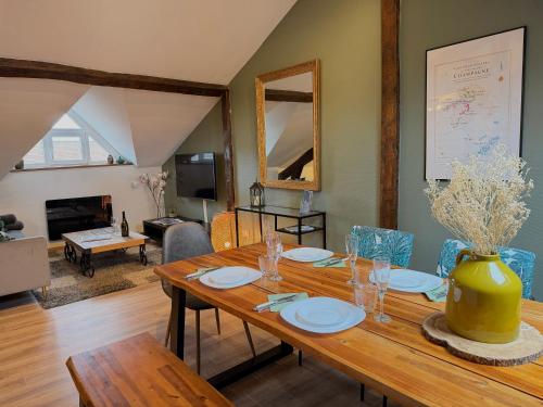 a dining room with a table and a living room at LE CHAMPENOIS-Appartement central près de l' Avenue de Champagne in Épernay