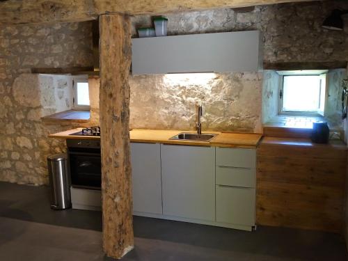 a kitchen with a sink and a stove at Cave Le Vieux Manoir in Valeilles