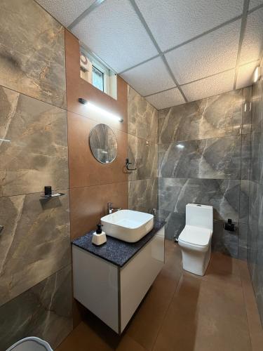 a bathroom with a sink and a toilet at Oblue Private Pool Villa in Cherai Beach