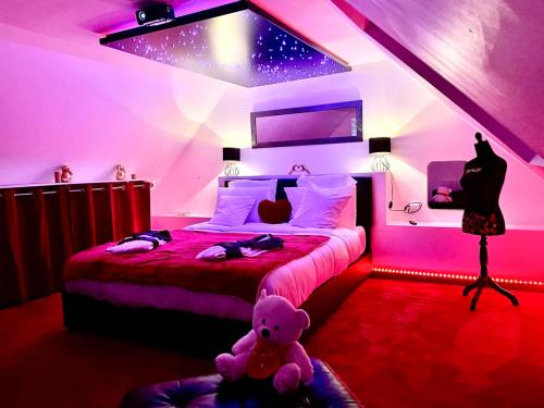 a bedroom with two beds and a teddy bear at Étoiles et Désirs in Kermaria-Sulard