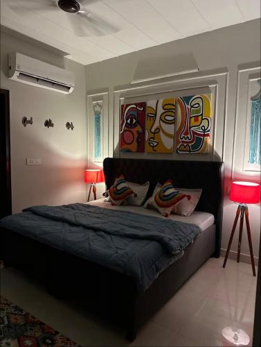 a bedroom with a bed with a painting on the wall at Vogue- Lavish collection in Zirakpur
