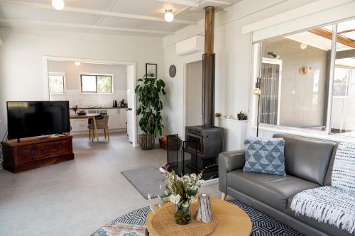 a living room with a couch and a tv at Secret Spot - Bruny Island in Lunawanna