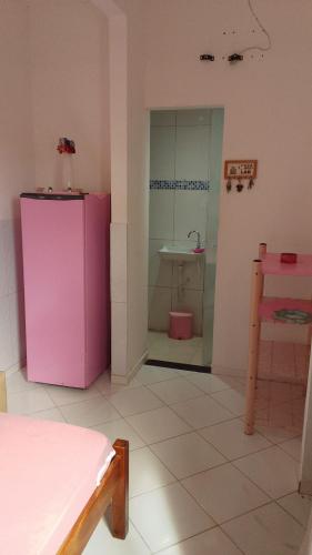 a room with a pink refrigerator and a sink at Casa Rosa da Ilha - Suíte Confortável com Ventilador e Jardim in Vera Cruz de Itaparica
