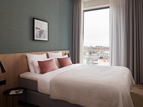 a bedroom with a large bed with a large window at Numa Amsterdam Docklands in Amsterdam