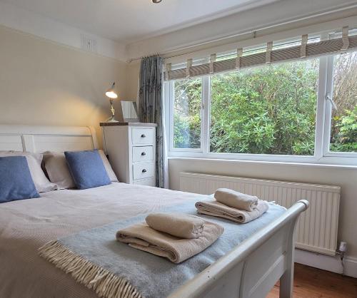 a bedroom with a bed with towels on it at Cosy room, en-suite with kitchenette in St. Davids