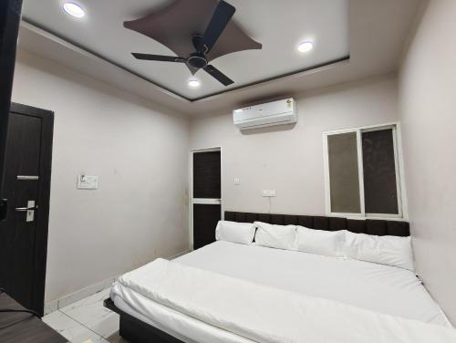 a bedroom with a bed with a ceiling fan at Hotel Rainbow palace in Ujjain