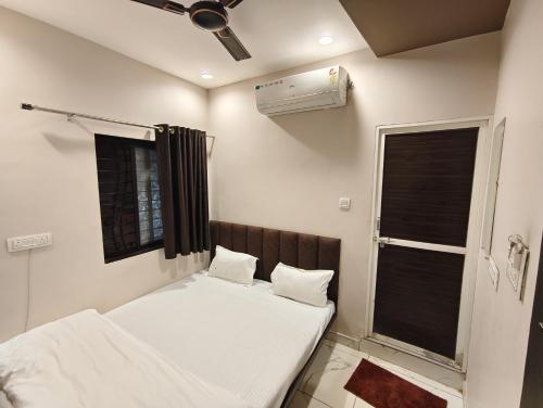 a bedroom with two beds and a air conditioner at Hotel Rainbow palace in Ujjain