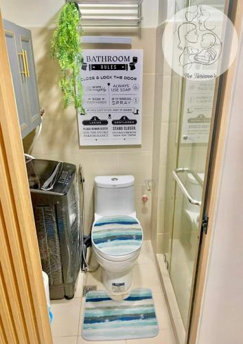 a bathroom with a toilet and a sign on the wall at The Turianos in Manila