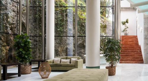 a living room with a couch and large windows at Blau Gran Hotel Las Caldas, a member of Radisson Individuals in Las Caldas