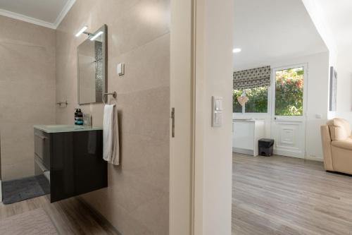 a bathroom with a shower with a sink and a mirror at Villa Liana by LovelyStay in Ponta do Sol