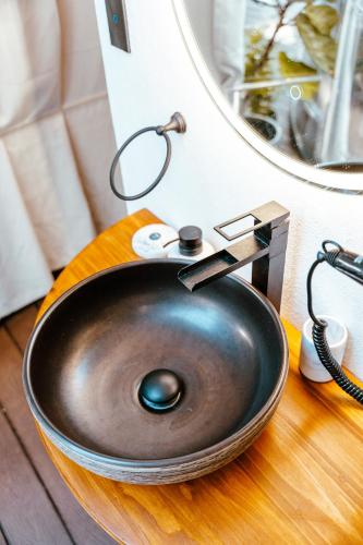 a metal sink on a wooden counter with a mirror at AMANI Casa Suite in San Rafael