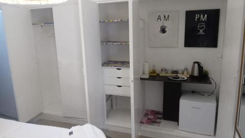 a bedroom with a white closet with a sink and a desk at Alojamiento San Nicolas in La Rioja