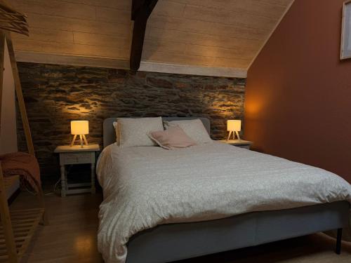 a bedroom with a bed with two lamps on two tables at La Ressource in Cherain