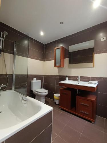 a bathroom with a tub and a sink and a toilet at Piso Rualte in Ávila