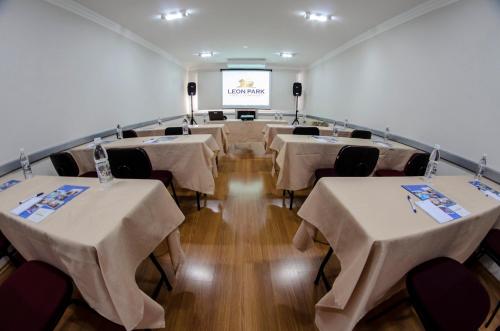 a conference room with tables and chairs and a screen at LEON PARK HOTEL e CONVENÇÕES - Melhor Custo Benefício in Campinas