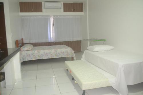 - une chambre avec 2 lits et un banc dans l'établissement Estúdio Ibiza II, à Maceió
