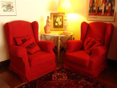 two red chairs and a table in a room at Pousada Villa Capivary Campos do Jordão in Campos do Jordão