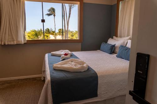 a bedroom with two beds with towels on them at Isla Beach Hotel in Pecém