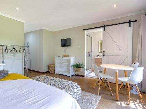 a bedroom with a bed and a table and chairs at The Horseshoe Guesthouse in Midrand