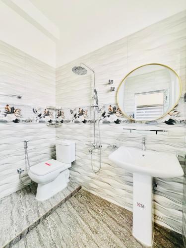 a bathroom with a sink and a toilet and a mirror at Rehan Sunset Villa in Negombo