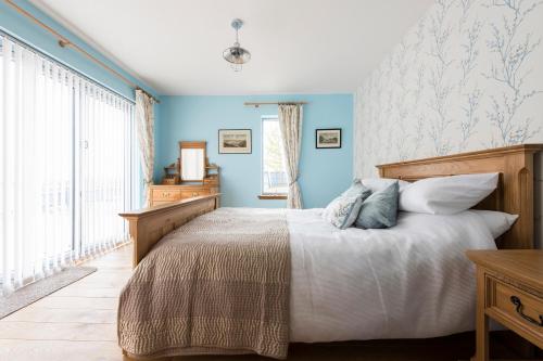 a bedroom with a bed with blue walls and a window at Tangle Tower in Inverness