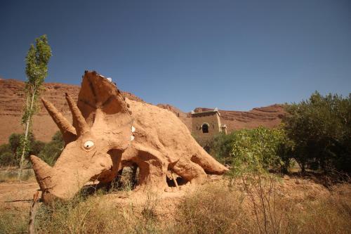 a statue of a dinosaur in the desert at Kasbah Hotel Camping Jurassique in Ifri
